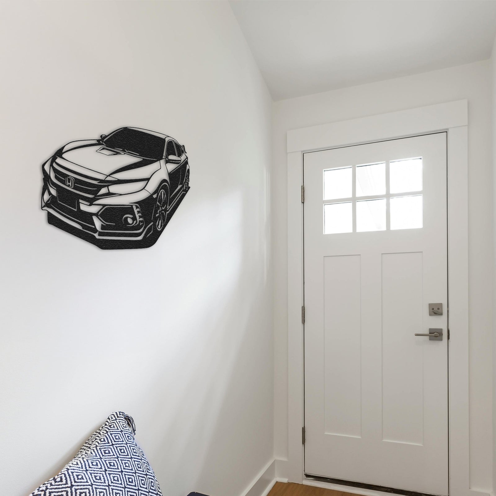 a room with a white door and a black and white car on the wall